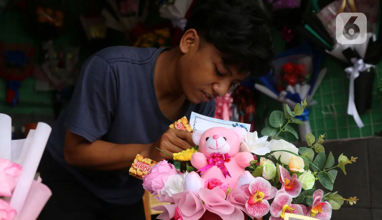 Penjual tengah menata bunga mawar yang dihias dengan boneka,uang dan coklat di Rawa Belong, Jakarta, Senin (14/2/2022). Hari Valentine yang diperingati setiap 14 Februari menjadi berkah bagi para penjual bunga karena banyak pesanan bunga di momen kasih sayang tersebut. (Liputan6.com/Angga Yuniar)