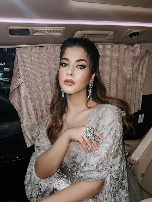 Beauty vlogger Tasya Farasya turut hadir ke malam puncak Puteri Indonesia. Perempuan berdarah Arab ini tampil glamor berbalut dress brokat abu-abu dan perhiasan perak. (Instagram/tasyafarasya).
