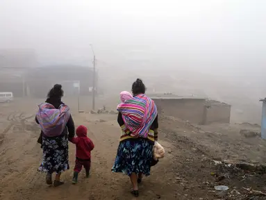 Warga berjalan melalui kabut dingin dan tebal pada hari resmi pertama musim dingin, di lingkungan Ticlio Chico di pinggiran Lima, Peru, Selasa (21/6/2022). Suhu di ibu kota adalah yang terendah dalam 25 tahun, menurut National Layanan Meteorologi dan Hidrologi Peru. (AP Photo/Martin Mejia)