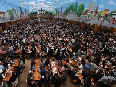 Pengunjung menikmati bir selama Festival Oktoberfest 2019 di sebuah tenda di Munich, Jerman selatan (3/10/2019). Festival bir terbesar di dunia Oktoberfest berlangsung hingga 6 Oktober 2019. (AFP Photo/Christof Stache)