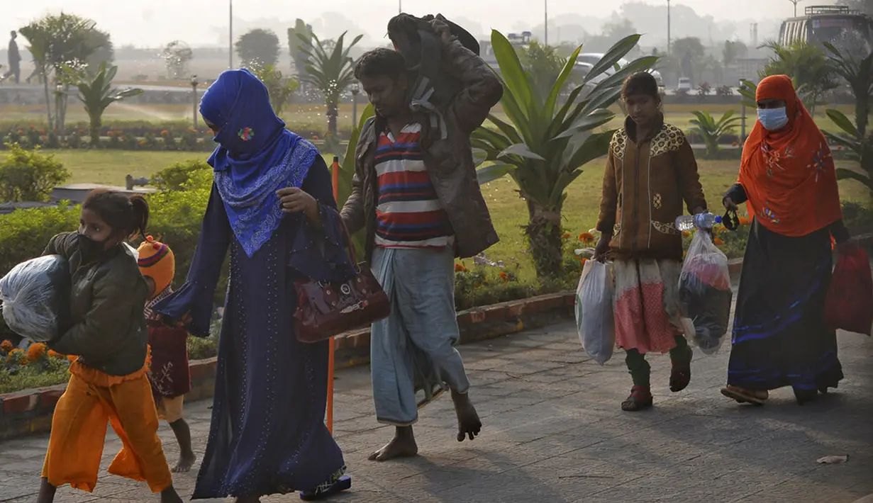 Pengungsi Rohingya membawa barang-barang mereka saat akan naik kapal Angkatan Laut yang memindahkan mereka ke Pulau Bhasan Char di Chattogram, Bangladesh, Sabtu (30/1/2021). Bangladesh terus berupaya untuk memulangkan lebih dari 1 juta pengungsi Rohingya ke Myanmar. (AP Photo/Azim Aunon)