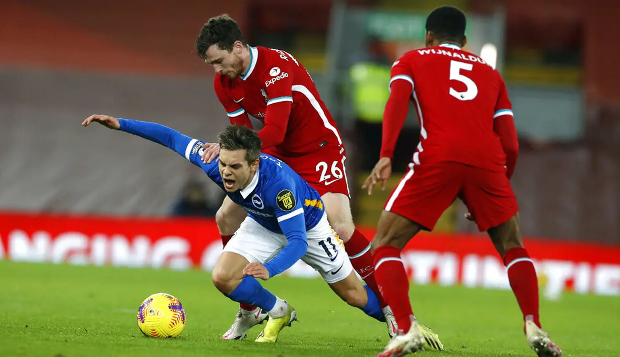 Pemain Brighton Leandro Trossard (kiri) berebut bola dengan pemain Liverpool Andrew Robertson pada pertandingan Liga Inggris di Anfield Stadium, Liverpool, Inggris, Rabu (3/2/2021). Brighton menang 1-0. (Phil Noble/Pool via AP)