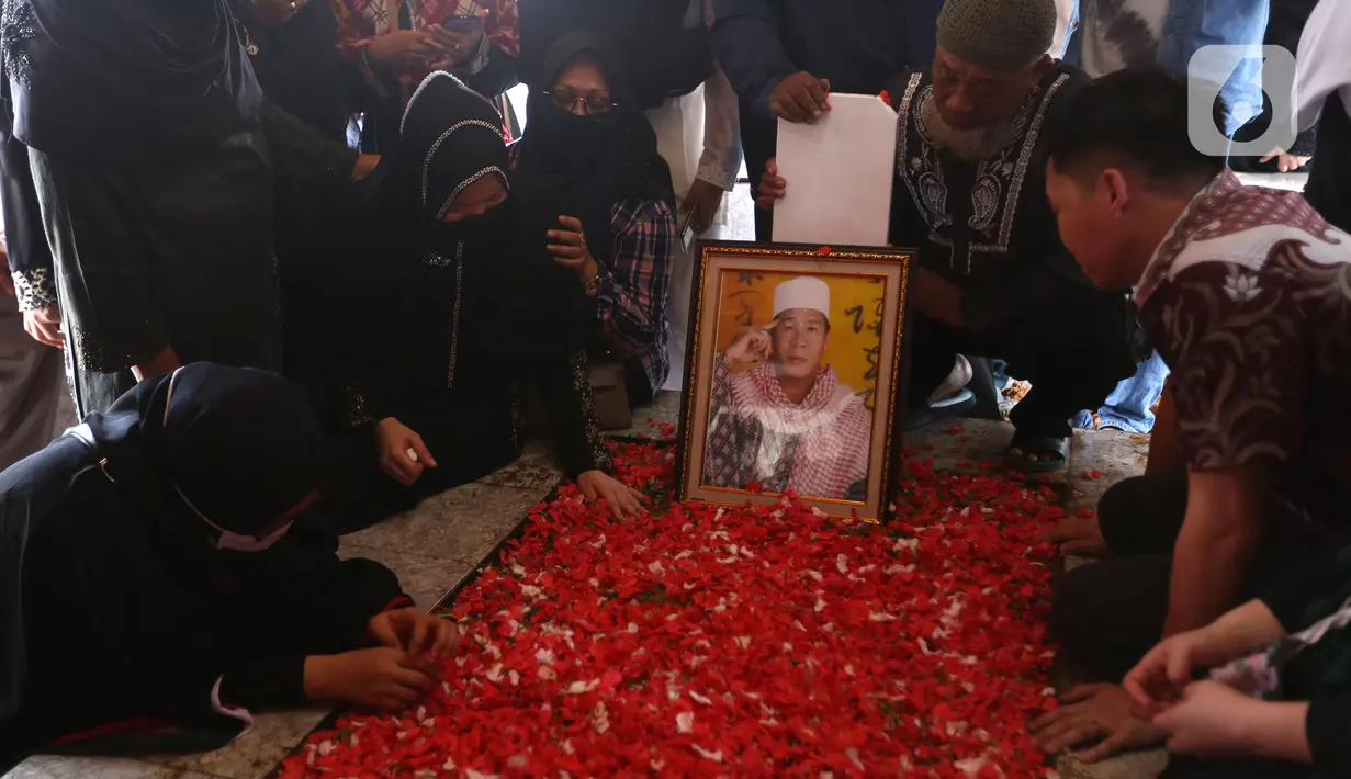 Sejumlah orang menangis di makam pendakwah Ramdhan Effendi atau Anton Medan saat pemakaman di area Masjid Tan Kok Liong, Pondok Rajeg, Cibinong, Bogor, Jawa Barat, Selasa (16/3/2021). Anton Medan punya perhatian lebih kepada para napi. (Kapanlagi.com/Budy Santoso)
