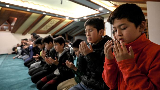 Anak-anak Uighur melaksanakan salat di sela-sela kegiatan belajar di sebuah sekolah di distrik Silivri, Istanbul, Turki (29/12/2019). (AFP/Ozan Kose)