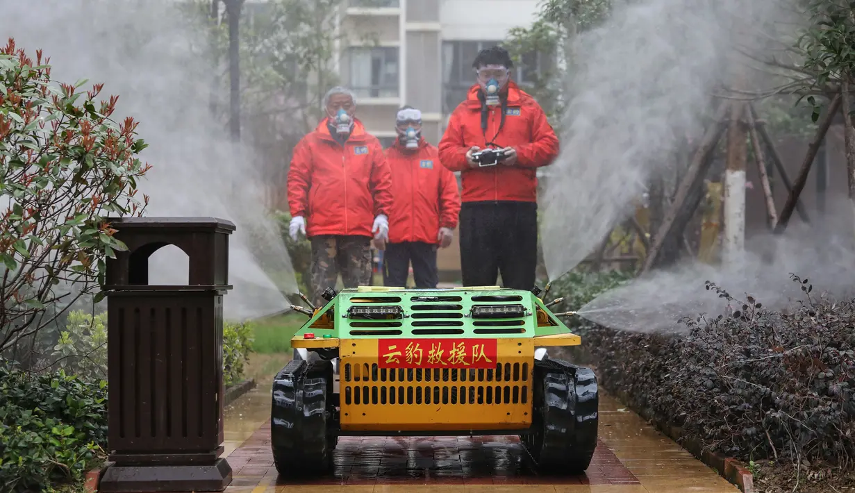 Sukarelawan menyemprotkan disinfektan dengan sebuah robot di sebuah area tempat tinggal di Wuhan di provinsi Hubei tengah China (3/3/2020). (AFP/STR)