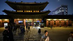 Gambar pada 4 Oktober 2019 memperlihatkan wisatawan saat kunjungan malam ke Istana Gyeongbokgung di pusat Seoul, Korea Selatan. Kunjungan malam tersedia pada minggu ketiga dan keempat setiap bulan mulai dari 26 April sampai 31 Oktober, kecuali pada bulan Agustus. (Photo by Ed JONES / AFP)