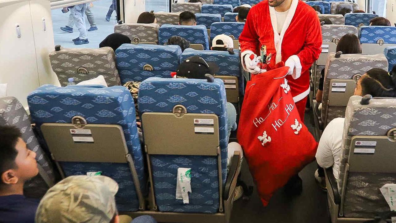 Petugas berkostum Sinterklas menyapa membagikan hadiah kepada penumpang kereta cepat Whoosh di Stasiun Kereta Cepat Halim, Jakarta, Minggu (24/12/2023). Dalam rangka menyambut Natal 2023, KCIC menghadirkan Sinterklas untuk menghibur para penumpang.&nbsp;<