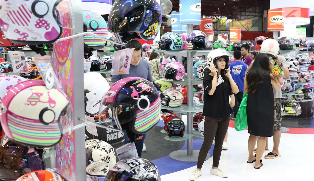 Seorang pengunjung menjajal helm di pameran Jakarta Fair 2018 di JIExpo Kemayoran, Jakarta, Rabu (23/5). Jakarta Fair 2018 ini diselenggarakan mulai 23 Mei hingga 1 Juli 2018. (Liputan6.com/Immanuel Antonius)