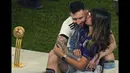 Antonela Ruccuzzo (kanan) mencium suaminya, Lionel Messi saat merayakan kemenangan Argentina di Piala Dunia 2022 setelah mengalahkan Prancis pada laga final yang berlangsung di Lusail Stadium, Qatar, Minggu (18/12/2022). Albiceleste menang 4-2 atas Prancis di babak penalti. (AP Photo/Francisco Seco)