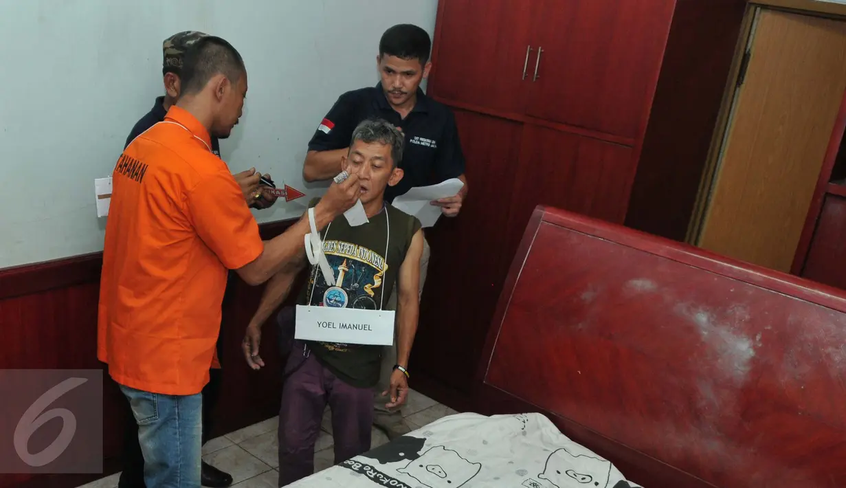 Salah satu adegan diperagakan Heri alias GW, tersangka pembunuhan Dayu Pri Ambarita dan anaknya Yuel Imanuel pada rekonstruksi pembunuhan sadis di Perumahan Aneka Elok, Cakung, Jakarta, Selasa (27/10). (Liputan6.com/Andrian M Tunay)