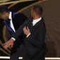 Will Smith (kanan) memukul presenter Chris Rock di atas panggung Piala Oscar 2022 saat mempersembahkan penghargaan untuk film dokumenter terbaik di Dolby Theatre, Minggu (27/3/2022). Will Smith merasa lawakan sang komedian terkait istrinya, Jada Pinkett Smith keterlaluan. (AP Photo/Chris Pizzello)