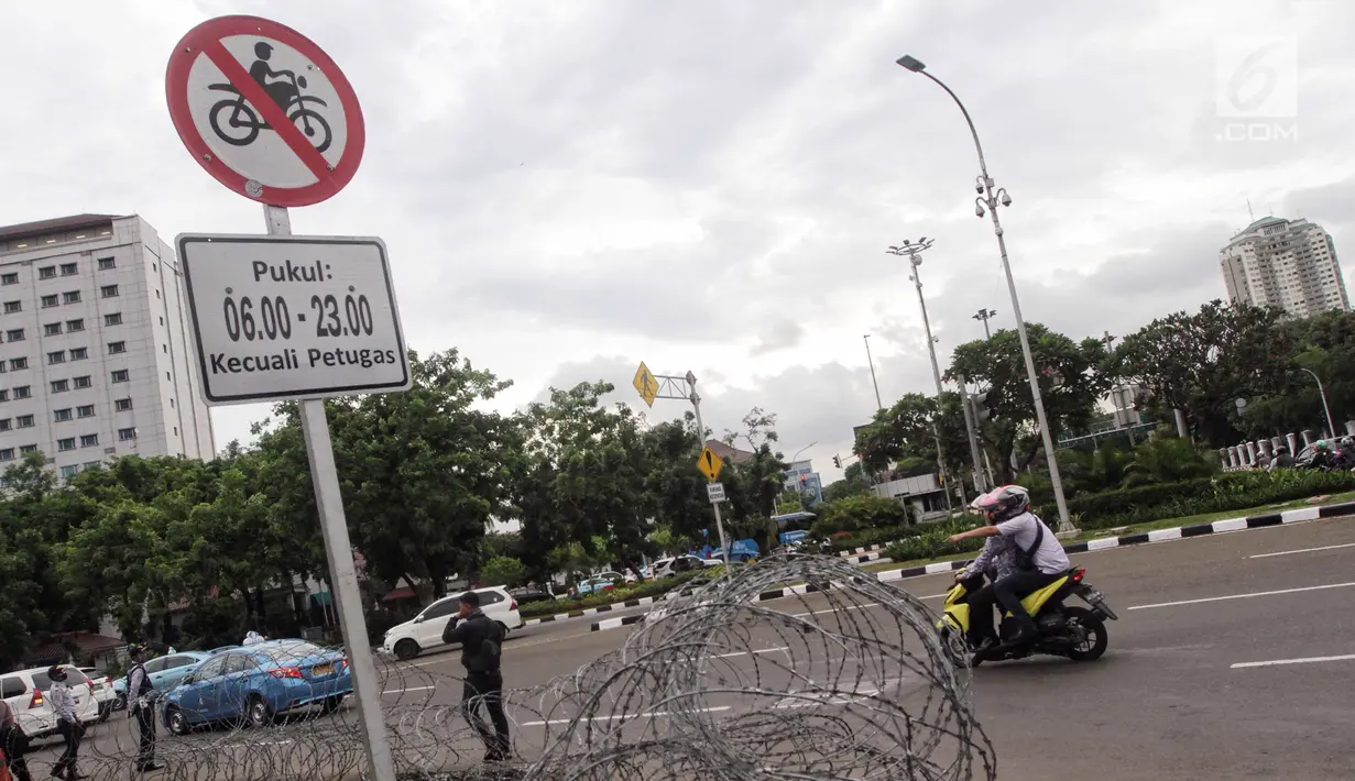 Plang pemberitahuan larangan sepeda motor melintas yang terpampang di jalan Medan Merdeka Barat, Jakarta, Selasa (7/11). Anies meminta ada perubahan agar motor bisa difasilitasi di Jalan MH Thamrin. (Liputan6.com/Faizal Fanani)