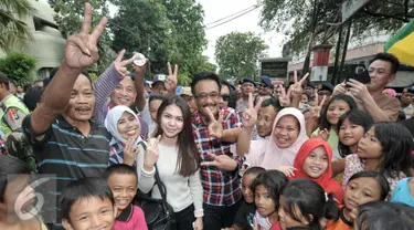 Calon wakil gubernur DKI Jakarta Djarot Saiful Hidayat berfoto bersama warga saat blusukan di Pasar Bedeng, Palmerah, Jakarta Barat, Kamis (24/11). Dalam blusukannya, Djarot berdialog dengan pedagang dan warga di pasar. (Liputan6.com/Yoppy Renato)