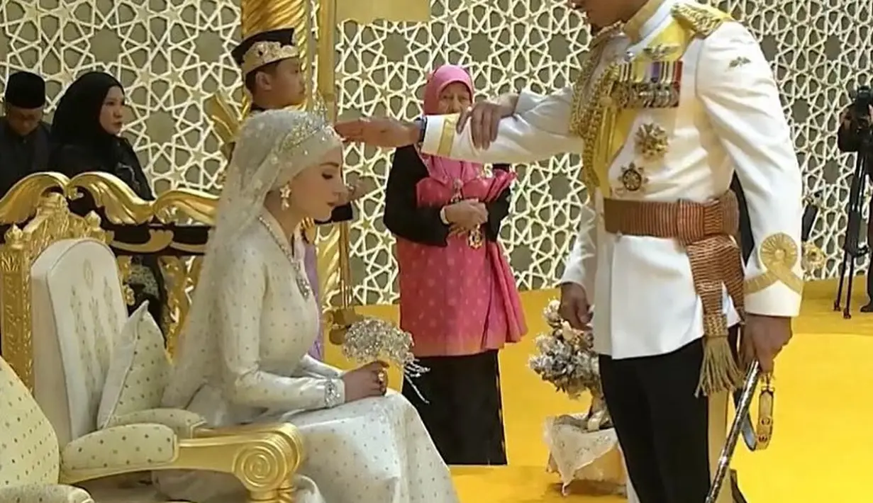 Pangeran Abdul Mateen dan Anisha Rosnah duduk bersama untuk upacara di Istana Nurul Iman. Keduanya juga menyapa masyarakat yang berkumpul di sepanjang jalan Ibu Kota Brunei Darussalam, Bandar Seri Begawan. [Foto: Instagram/thebridestory]