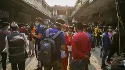Calon penumpang berdebat dengan staf bus untuk mendapatkan tiket kembali ke desa mereka sehari sebelum lockdown di Kathmandu, Rabu (28/4/2021). Puluhan ribu orang meninggalkan ibu kota Nepal sehari menjelang lockdown yang diberlakukan karena melonjaknya kasus COVID-19. (AP Photo/Niranjan Shrestha)