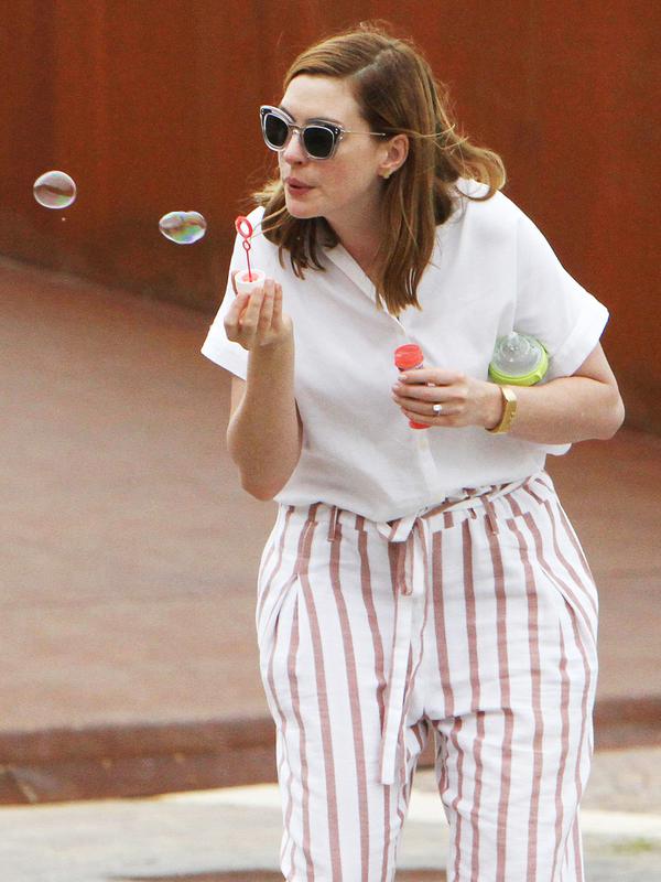Sama-sama di Venice, Anne Hathaway santai banget nih meniup balon sabun. (AMA/MEGA/USWeekly)