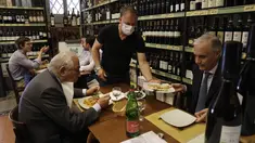 Pramusaji melayani pelanggan di dalam restoran di pusat kota Roma, Italia, Senin (1/6/2021). Mulai Selasa, pelanggan kembali diizinkan mengakses bar dan restoran, yang sebelumnya hanya diizinkan untuk melayani makan di luar ruangan atau takeaway karena pembatasan Covid-19. (AP Photo/Gregorio Borgia)