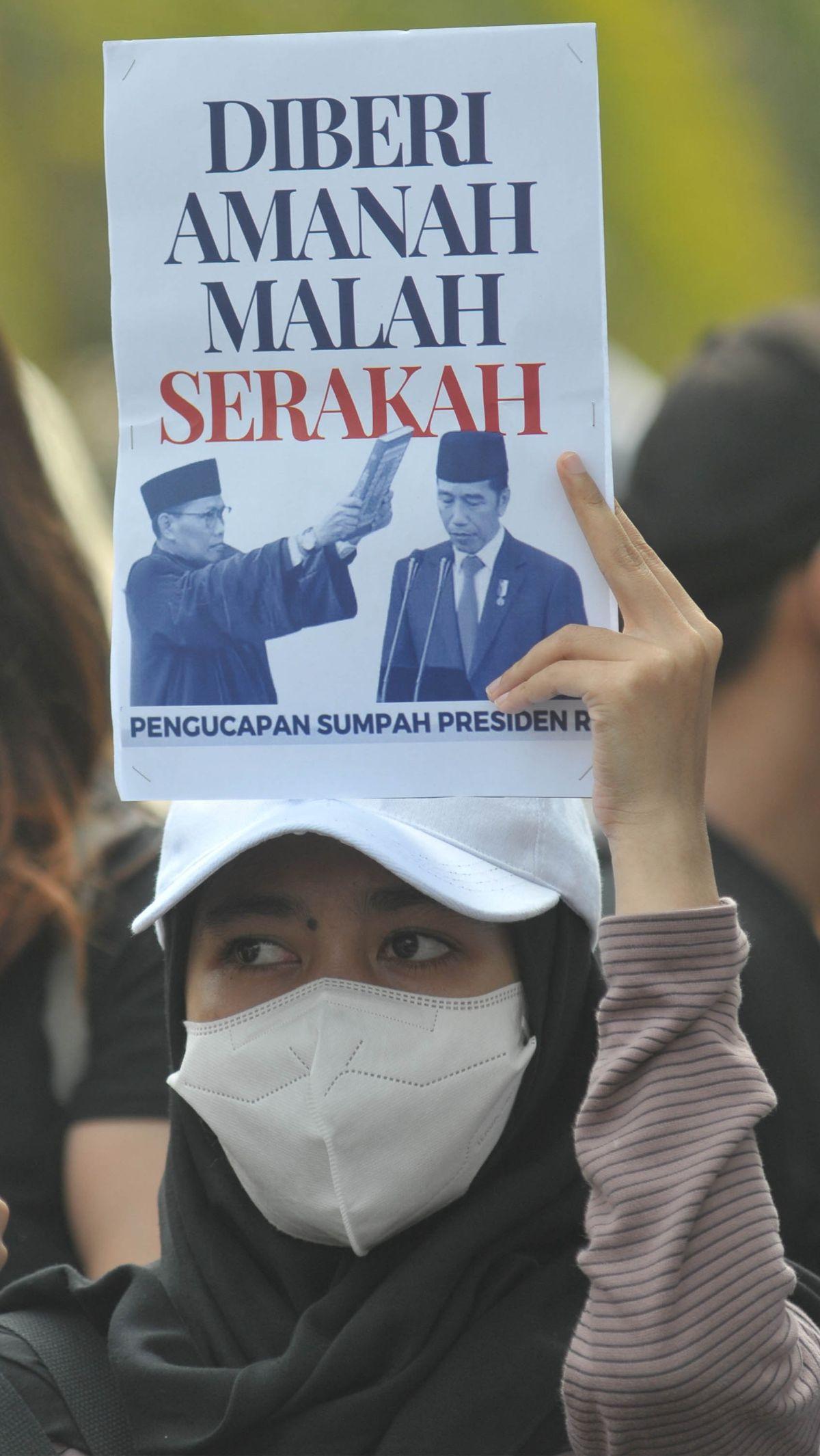 Pengunjuk rasa mengangkat poster bergambar Presiden Joko Widodo dengan tulisan: "Diberi amanah malah serakah." Foto: Merdeka.com/Imam Buhori