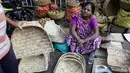 Seorang wanita menjual perlengkapan ibadah di sebuah kios pinggir jalan menjelang festival Hindu Chhath, di Kolkata, India (9/11/2021). Selama Chhath, festival Hindu kuno yang populer di kalangan kelas pekerja, ritual dilakukan untuk berterima kasih kepada Dewa Matahari. (AP Photo/Bikas Das)