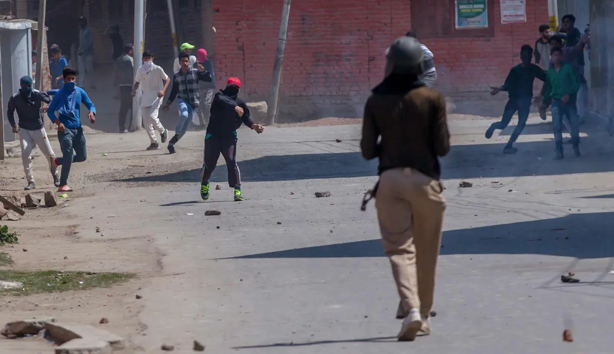 Para pemuda Kashmir melempari batu ke arah tentara paramiliter India di Srinagar, Kashmir, India, (1/4). Pengunjuk rasa memprotes menyusul tewasnya delapan pemberontak dalam bentrokan dengan pasukan pemerintah. (AP Photo / Dar Yasin)