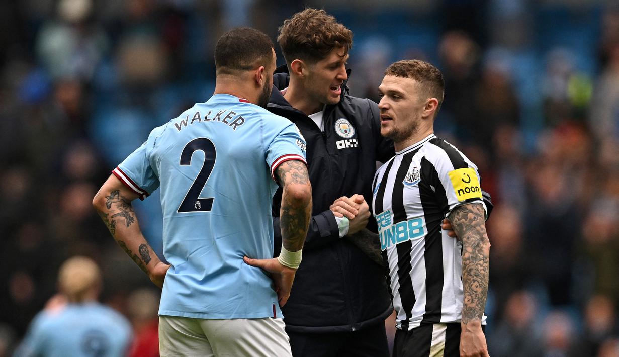 Bek Newcastle United, Kieran Trippier (kanan) berbincang dengan bek Manchester City, John Stones (tengah) dan Kyle Walker setelah usai berakhirnya laga lanjutan Liga Inggris 2022/2023 di Etihad Stadium, Manchester, Sabtu (4/3/2023) malam WIB. (AFP/Paul Ellis)