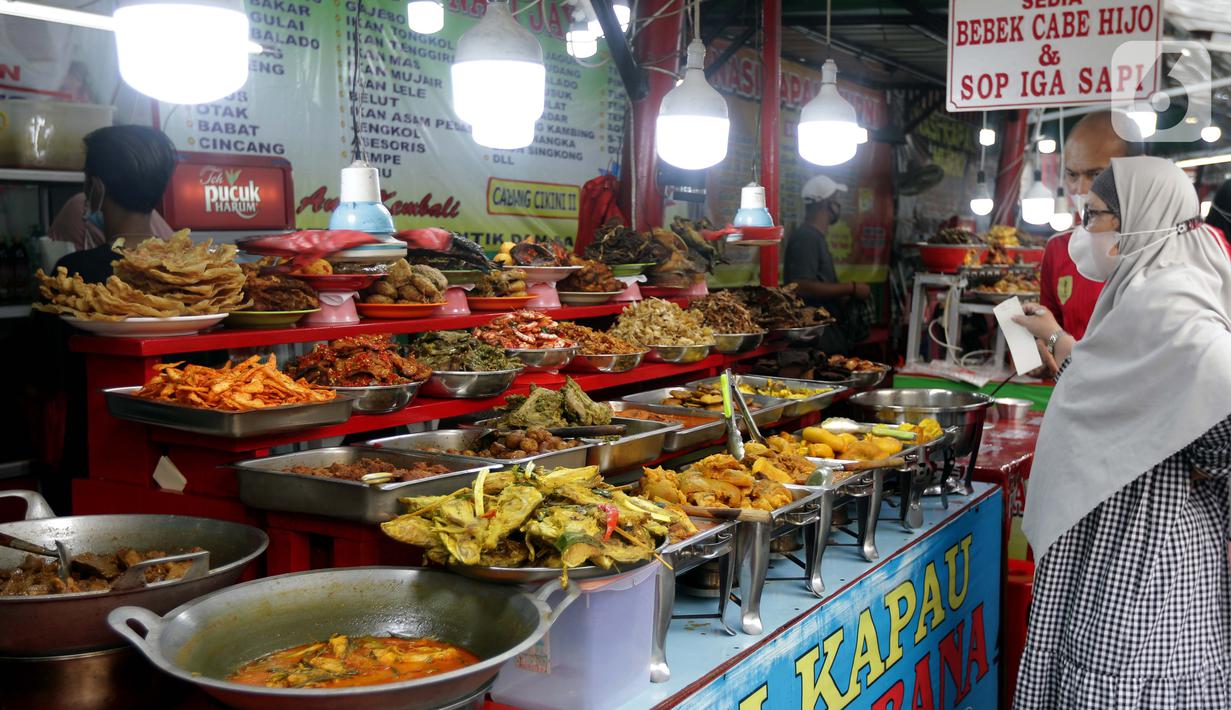 Warga memilih menu makanan khas Sumatera Barat yang dijajakan di kawasan Food Street Kramat, Jakarta, Jumat (30/4/2021). Kawasan yang menjual beragam menu makanan khas Sumatera Barat selalu ramai dikunjungi pecinta kuliner terutama jelang waktu berbuka puasa. (Liputan6.com/Helmi Fithriansyah)