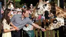 Pangeran William dan Kate Middleton terlihat begitu mesra saat menyempatkan memberi makan Jerapah di kebun binatang Taronga, Sydney, Australia, (20/4/2014). (REUTERS/Chris Jackson)
