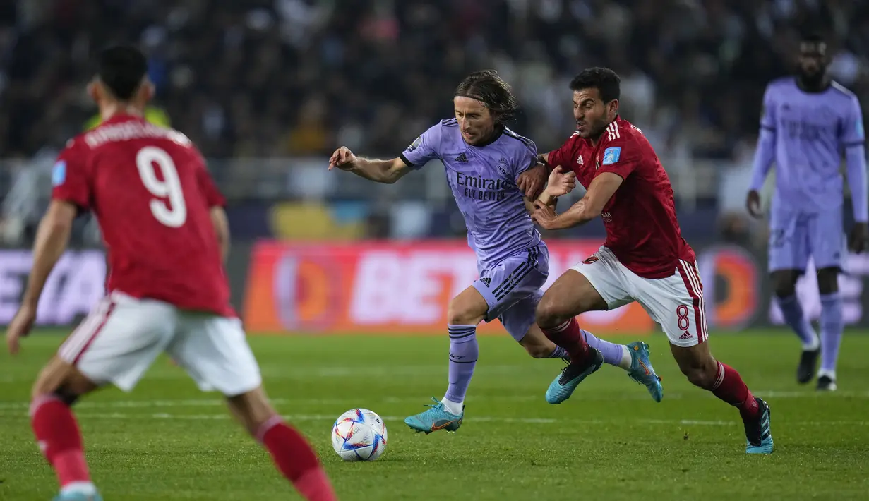 Gelandang Real Madrid Luka Modric berebut bola dengan gelandang Al-Ahly Hamdy Fathy dalam duel semifinal Piala Dunia Antarklub 2022 di Prince Moulay Abdellah Stadium, Maroko, Kamis (9/2/2023) dini hari WIB. Skuad Los Blancos  lebih diunggulkan di atas kertas. (AP Photo/Manu Fernandez)