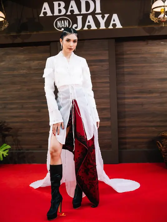 Mikha Tambayong tampil edgy dengan kebaya putih panjang yang dipadu dengan wrapped skirt asimetris. Sebagai penutup, ia kenakan heels boots tinggi yang jadi statement [@miktambayong]