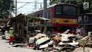 Kereta listrik melintas di sebelah bongkaran rumah di area Rusun Bendungan Hilir (Benhil) II, Jakarta, Minggu (3/12). (Liputan6.com/JohanTallo)