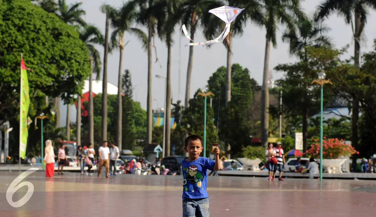 Seorang anak berusaha menerbangkan layang layang saat bermain di Lapangan Monumen Tugu Pancasila TMII, Jakarta, Jumat (8/7). TMII masih menjadi lokasi favorit warga menghabiskan libur hari raya. (Liputan6.com/Helmi Fithriansyah)