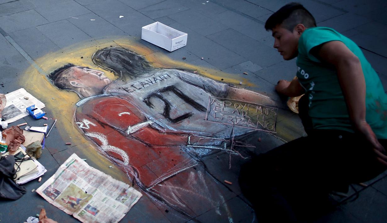 Seniman Chili melukis tindakan provokasi Gonzalo Jara terhadap pemain Uruguay, Edinson Cavani di trotoar jalan di Santiago, Chili (28/6/2015). Konfederasi Sepak Bola Amerika Selatan menghukum Gonzalo Jara bermain di tiga laga. (REUTERS/Marcos Brindicci)