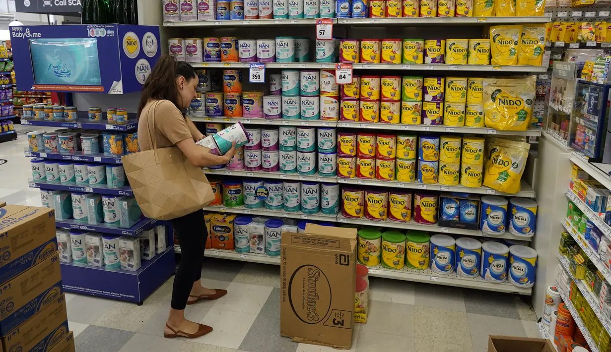 Michelle Saenz dari Santee, California memilih susu formula di toko kelontong di seberang perbatasan di Tijuana, Meksiko, Selasa (24/5/2022). Saat susu formula di sejumlah supermarket Amerika Serikat hampir kosong, justru rak-rak susu di supermarket Meksiko terlihat penuh dengan berbagai pilihan. (AP Photo/Gregory Bull)