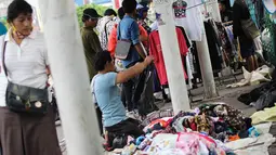 Para pembeli melihat-lihat barang dagangan yang digelar di sepanjang trotoar Jalan Senen Raya, Minggu (27/4/14). (Liputan6.com/Faizal Fanani)  