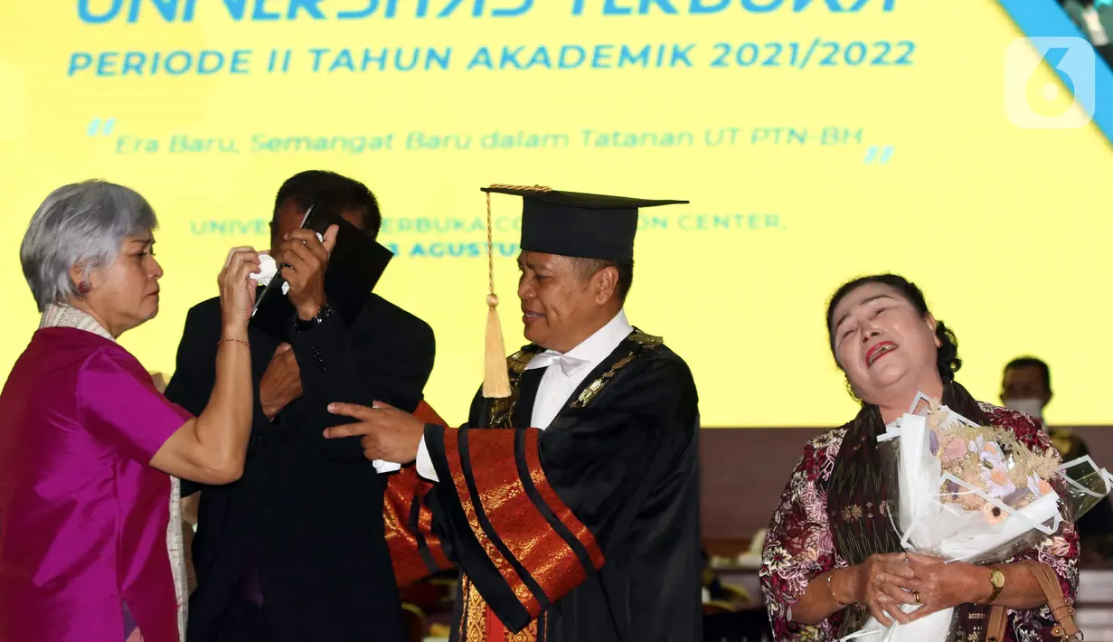 Ketua Komunitas Civil Society Indonesia Irma Hutabarat (kiri) mengusap air mata ayah Brigadir Nofriansyah Yosua Hutabarat atau Brigadir J, Samuel Hutabarat saat mewakili anaknya mengikuti prosesi wisuda di Universitas Terbuka, Pamulang, Tangerang Selatan, Banten, Selasa (23/8/2022). Brigadir J lulus memuaskan dengan IPK 3,28. (Liputan6.com/Herman Zakharia)