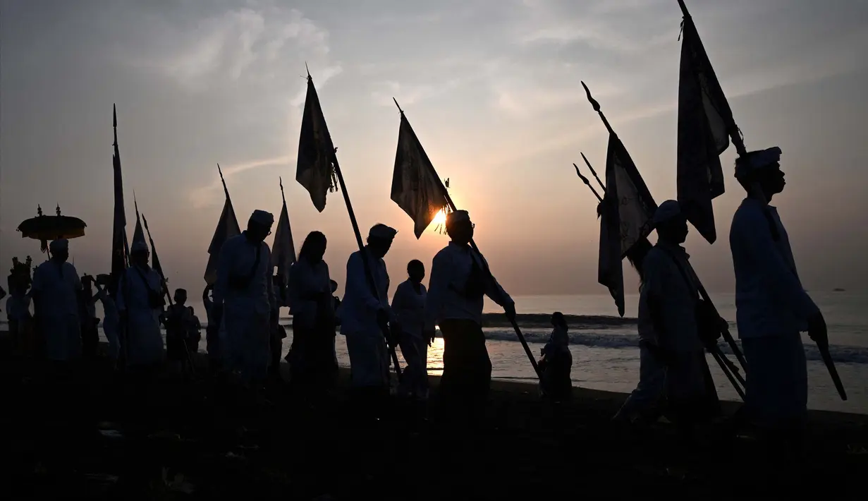 Masyarakat Bali berjalan untuk berdoa selama upacara Melasti di salah satu pantai, Denpasar, Bali, pada 8 Maret 2024. (SONNY TUMBELAKA/AFP)