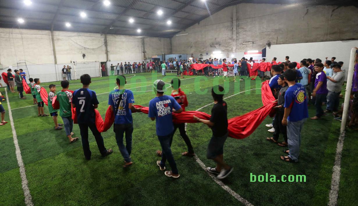 Suporter bahu-membahu ikut dalam kegiatan menjahit bendera Merah-Putih raksasa di Tangerang, Sabtu (31/10/2015). Selain ingin mencatat rekor dunia, tema dasar adalah "One Soul, One Nation Untuk Sepakbola Indonesia".  (Bola.com / Nicklas Hanoatubun).