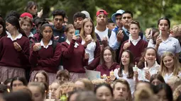 Para pelajar menggelar aksi lilin saat mengenang korban penembakan di luar Masjid Al Noor, Christchurch, Selandia Baru, Senin (18/3). Sebanyak 50 orang tewas dalam insiden tersebut. (AP Photo/Vincent Yu)
