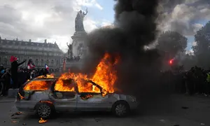 Sebuah mobil terbakar di Lapangan République saat aksi demonstrasi menentang kenaikan biaya hidup dan menyuarakan keluhan mahasiswa di Paris, Prancis, Sabtu (17/10/2026). (AP Photo/Thibault Camus)