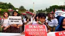 Massa membentangkan spanduk dalam aksi meminta revisi UU KPK di depan Istana, Jakarta, Jumat (13/9/2019). Dalam aksinya, mereka juga mendukung keberadaan Dewan Pengawas KPK agar KPK tetap independen dan bebas dari intervensi politik. (Liputan6.com/Johan Tallo)