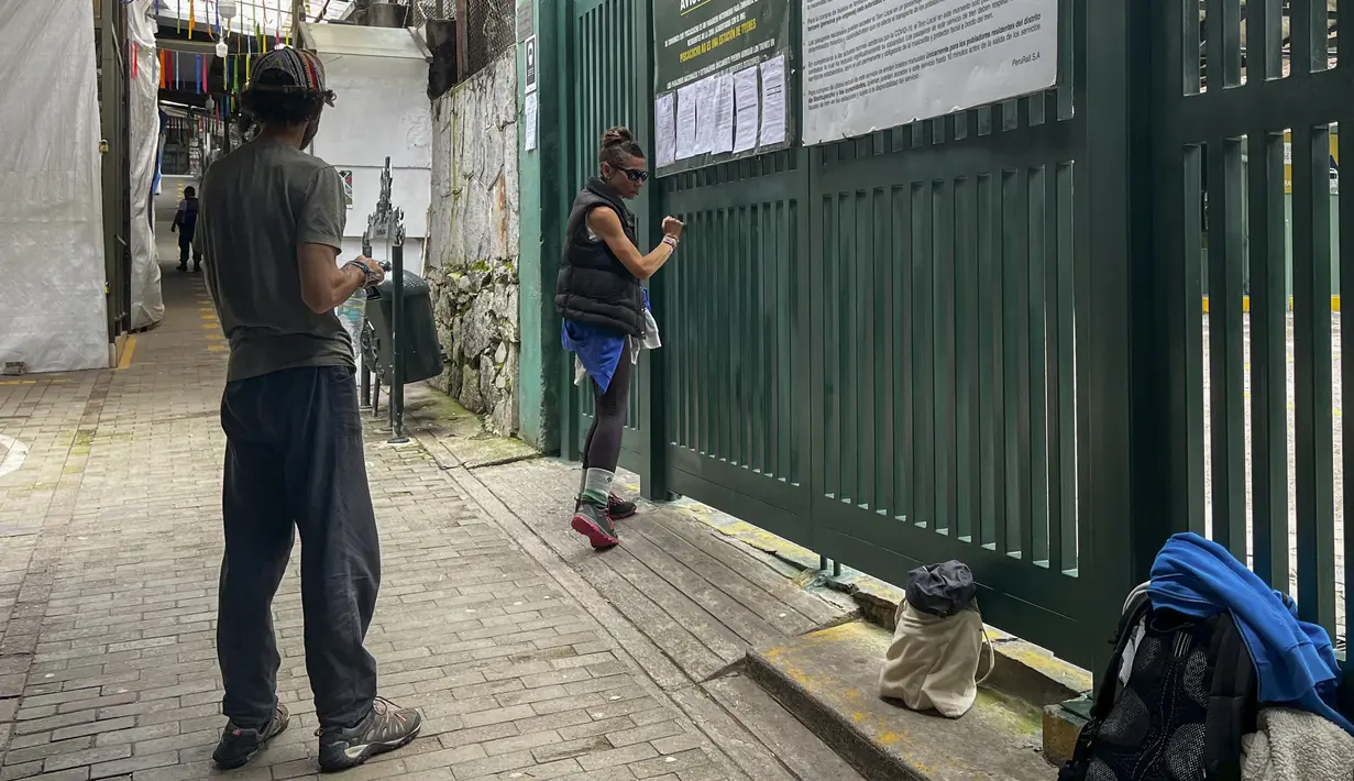 Turis menunggu di luar stasiun kereta Machu Picchu setelah layanan kereta api dihentikan karena kerusakan yang diduga disebabkan oleh pengunjuk rasa di Machu Picchu, Peru, Sabtu (21/1/2023). Penutupan tersebut dilakukan demi melindungi warga dan juga turis yang ada di sana. (Photo by Carolina Paucar / AFP)