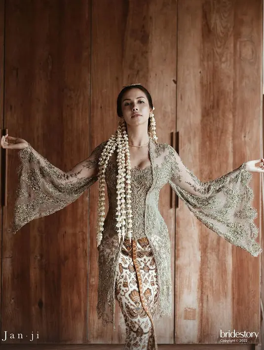 Estelle Linden menikah kenakan kebaya modern warna hijau sage yang apik rancangan Didiet Maulana. Kebayanya menampilkan kreasi manis pada lengan yang menjuntai seperti sayap merpati, menambahkan pesona elegan bagi pengantin.  [@svarna_byikatindonesia].