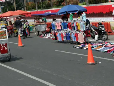 Pedagang kaki lima (PKL) menggelar dagangannya di Jalan Jenderal Sudirman saat Hari Bebas Kendaraan, Jakarta, Minggu (25/8/2019). Para PKL ini menggelar dagangannya terlalu menjorok ke tengah jalan sehingga mengganggu kenyamanan warga yang berolahraga saat CFD. (Liputan6.com/Helmi Fithriansyah)