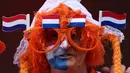 Seorang pendukung Belanda berkacamata hitam dan mengenakan bendera Belanda berpose sebelum pertandingan sepak bola Euro 2024 Grup D antara Belanda dan Prancis di Stadion Leipzig, Leipzig, pada 21 Juni 2024. (Adrian DENNIS/AFP)