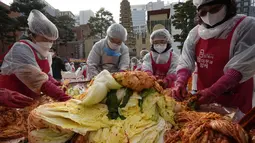 Relawan membuat LIPkimchi untuk disumbangkan kepada tetangga yang membutuhkan, di sebuah kuil di Seoul, Korea Selatan, Kamis (2/12/2021). Sekitar 200 orang membuat 4.000 bungkus kimchi, dibuat dari fermentasi sayuran, seperti sawi putih, lobak, yang diberi bumbu pedas. (AP Photo/Ahn Young-joon)