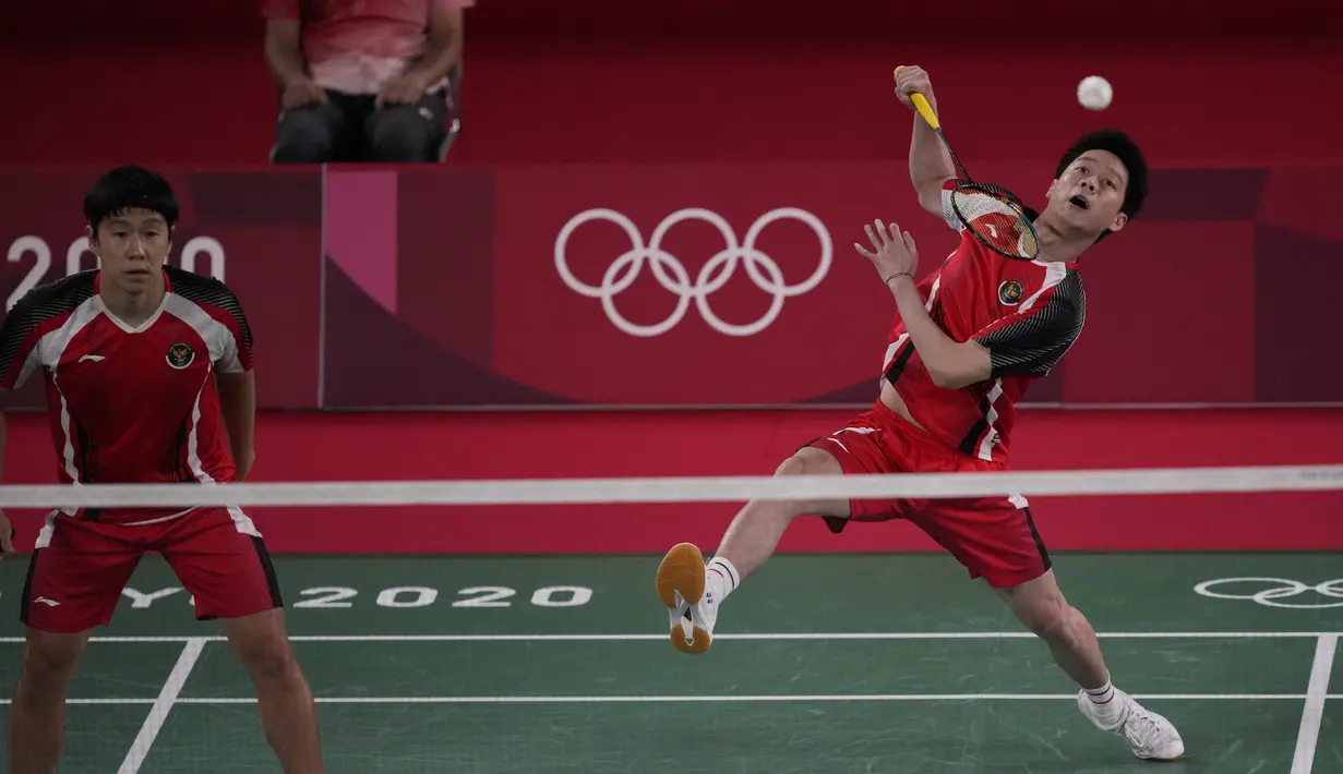 Ganda putra Indonesia Marcus Gideon (kiri) dan Kevin Sanjaya Sukamuljo bersaing dengan Ben Lane dan Sean Vendy dari Inggris pada pertandingan ganda putra Grup A Olimpiade Tokyo  2020 di Musashino Forest Sports Plaza, Sabtu (24/7/2021). Kevin / Marcus menang 21-15, 21-11 (AP Photo/Dita Alangkara)