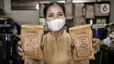 Pekerja menunjukkan kopi yang siap dipasarkan di toko kopi Sari Murni, Jatinegara, Jakarta Timur, Selasa (4/1/2021). Toko kopi yang berdiri sejak tahun 1952 ini juga dikenal dengan Kopi Cap Sedan. (merdeka.com/Iqbal S. Nugroho)