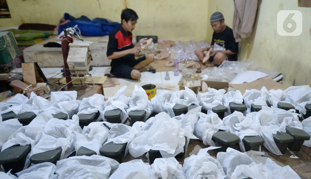 Pekerja sedang menyelesaikan produksi home industri sepatu wanita pesanan pembeli di Pamulang, Tangerang Selatan, Banten,  Rabu (14/10/2020). Pada masa pandemi ini pemesanan sepatu turun 40 persen dibandingkan sebelum Covid-19. (merdeka.com/Dwi Narwoko)
