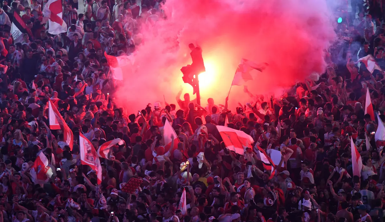 Suporter River Plate membakar flare saat merayakan gelar juara Copa Libertadores di Obelisk, Buenos Aires, Argentina, Minggu (9/12). River Plate merebut gelar juara Copa Libertadores usai menaklukkan Boca Juniors. (AP Photo/Gustavo Garello)