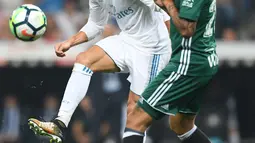 Penyerang Real Madrid, Cristiano Ronaldo berebut bola dengan pemain Real Betis dalam laga pekan lima La Liga di Santiago Bernabeu, Rabu (20/9). Real Madrid keok 0-1 dari tamunya, Real Betis. (GABRIEL BOUYS/AFP)